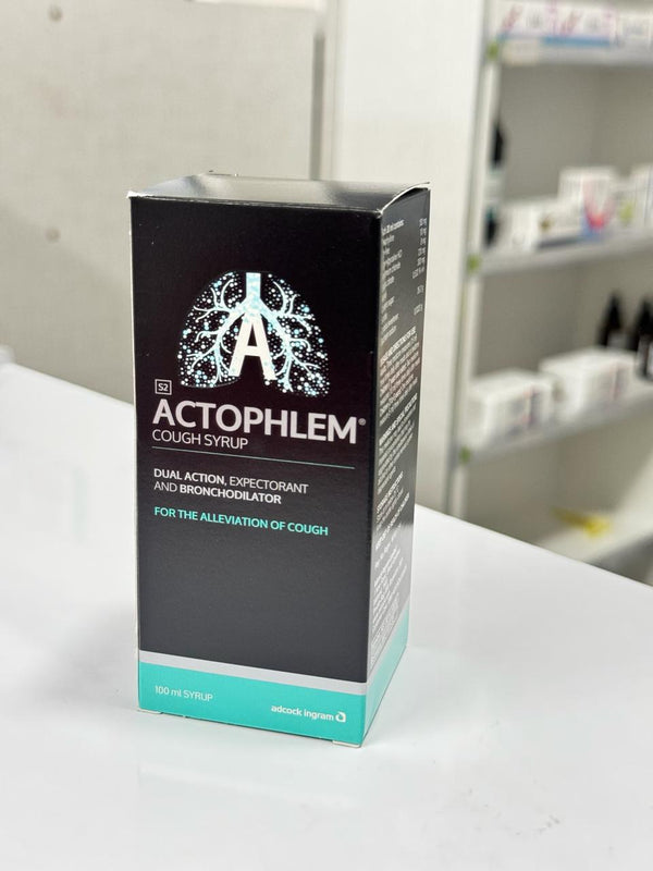 Actophlem cough syrup packaging on a white surface with a blurred background