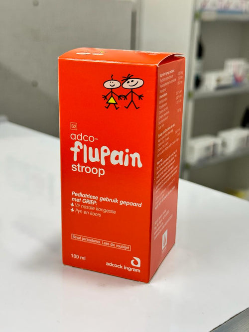 Red box of adco-flupain stroop on a white surface with a blurred background