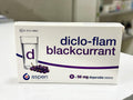 Box of diclo-flam blackcurrant tablets by Aspen on a white surface.