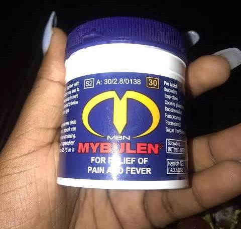 Container of MYBULEN for relief of pain and fever held in a hand.